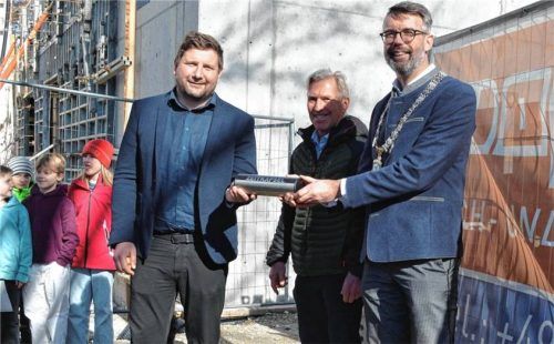 Historischer Moment: (von links) Schulleiter Marcus Ullrich, Bauleiter Michael Mayer und Bürgermeister Stefan Kattari betonierten die Zeitkapsel ein. Foto Eder