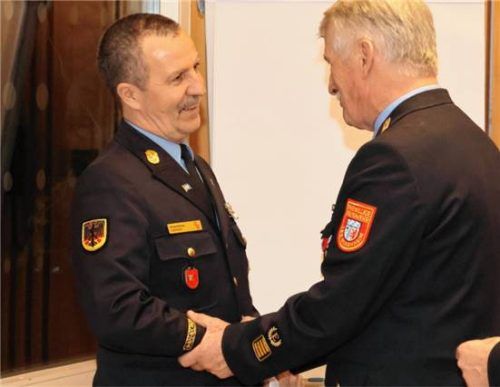 Richard Schrank wurde mit 85,8 Prozent im Amt bestätigt. Der frühere Kreisbrandrat Sebastian Ruhsamer gratulierte herzlich. Foto Landratsamt Rosenheim