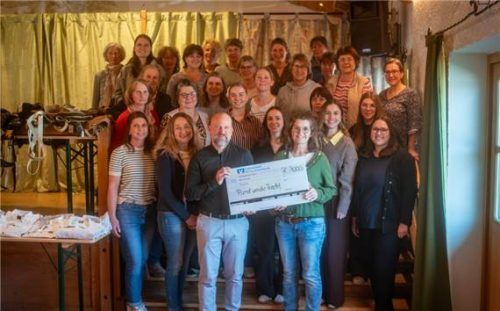 Scheckübergabe an die Franziskusschule Aschau: Schulleiter Michael Langner, und Maria Wackerbauer, eine der Mitorganisatorinnen vom Trachtenmarkt „Rund um die Tracht“ sowie der gesamte Helferkreis des Frasdorfer Trachtenmarktes. Foto Tobias Volke