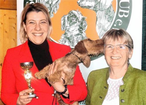Siegen ist schon was Feines, meinte Frauchen Katja Schumann (links) über ihren jungen Rauhaar-Rüden „Dorian Gay Vitoraz“, der sich bei Richterin Doris Vetsch auf besondere Art bedankte. Fotos Strim