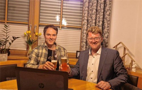 Verfolgen die Wahlergebnisse gemeinsam im Wohnzimmer der Familie Empl am Laptop: Schwindeggs wiedergewählter Bürgermeister Roland Kamhuber (rechts) und der langjährige Weggefährte Tobias Empl (Zweiter Vorsitzender FWG Schwindegg). Foto privat