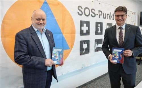 „Vorsorgen für Krisen und Katastrophen“: Der Landkreis hat 45.000 Informationsbroschüren bestellt. Stellvertretend nahm Bürgermeistersprecher Thomas Einwang (links) eine Broschüre von Landrat Max Heimerl in Empfang. Im Hintergrund das Banner, das in Zukunft die SOS-Punkte vor Ort kennzeichnen wird.Foto Landratsamt