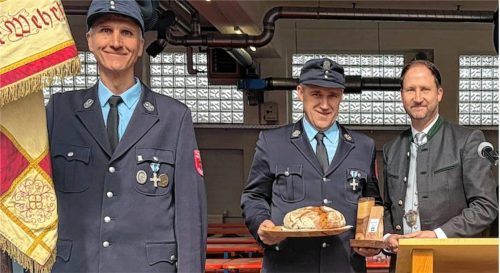 Zur feierlichen Eröffnung des Feuerwehrgerätehauses in Riedering überreichte Bürgermeister Christoph Vodermaier (rechts) dem Vorsitzenden des Feuerwehrvereins, Josef Loferer (Mitte), Brot und Salz. Fotos Kirchner