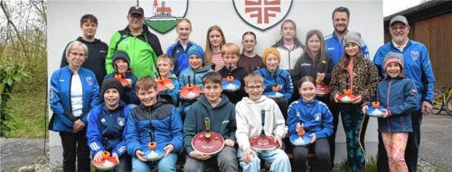 18 Kinder und Jugendliche freuten sich gemeinsam mit ihrem Trainerteam Lore Michel (links im Bild) und Reinhold Michel (rechts im Bild) sowie den Vereinsvorsitzenden Franz Eichberger (Zweiter von links, hinten) und Andreas Selmaier (Zweiter von rechts, hinten) über die neuen Stöcke, deren Anschaffung zwei Banken ermöglichten. Foto Wagner