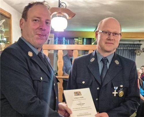 Der Erste Kommandant Thomas Braun überreicht Anton Linderer die Urkunde für 25 Jahre im aktiven Feuerwehrdienst. Foto Mann