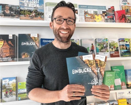 Der Geschäftsführer des Tourismusverbands, Josef Geisberger, präsentiert die neue Imagebroschüre vor dem umfangreichen Inforegal im Eingangsbereich des Tourismusverbands-Büros in Altötting. Foto  Inn-Salzach Tourismus