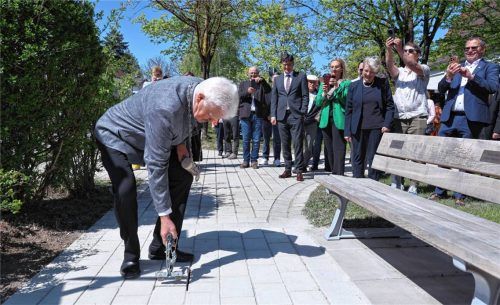 Der letzte Akt der Stadtplatzsanierung: Bürgermeister Erwin Baumgartner setzt den Schlussstein. Und zwar nicht irgendwo, sondern am Bankerl von Emil Steinbach. Dessen Witwe Juliane (im Hintergrund) war von der wertschätzenden Symbolik gerührt. Fotos  Enzinger