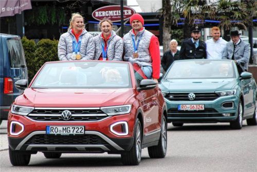Die erfolgreichen Rodel-Doppelsitzer bei den Damen (von links) Dajana Eitberger und Magdalena Matschina sowie Anschieber und Bremser im Zweierbob Alexander Schaller beim Einzug in Richtung Rathaus. Im Fahrzeug dahinter sind die Junioren-Weltmeister im Viererbob zu sehen. Foto Strim