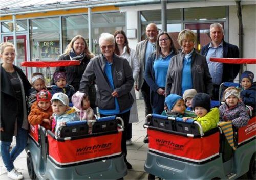 Die Leiterinnen Katharina Brucia und Stefanie Weber, Inge Schnabl, Heidi Hufeld und Eva Köhr von „Sterntaler“, dazwischen Bürgermeister Sepp Eisner hinter den beiden gespendeten Krippenwagen mit Alina Philipeit und Markus Krause von der Gemeindeverwaltung.Foto  Fischer