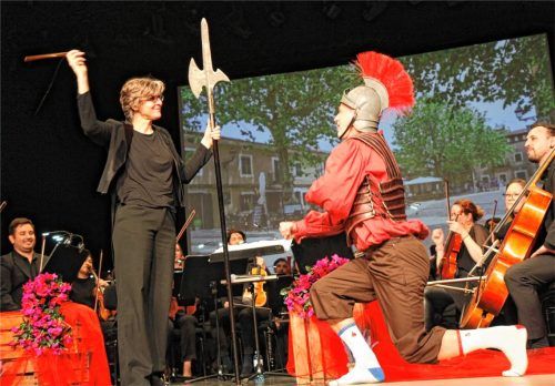 Dirigentin Elisabeth Fuchs schlägt Torsten Hermentin als Don Quixote zum Ritter – natürlich nicht mit einem Schwert, sondern, wie könnte es anders sein, mit einem Geigenbogen. Foto ahn
