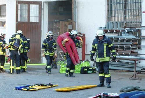 Ein Feuerwehrmann trägt eine Puppe aus dem rauchenden Gebäude heraus. Insgesamt mussten acht vermisste „Personen“ in dem stark verrauchten Magazin gefunden werden.