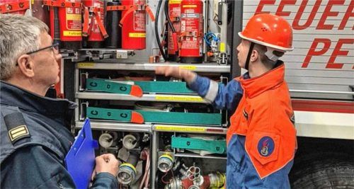 Ein Traunsteiner Ausbilder der Feuerwehr lässt sich vom Nachwuchs erklären, welche Geräte und Feuerlöscher im Einsatzfahrzeug untergebracht sind. Foto Hobmaier