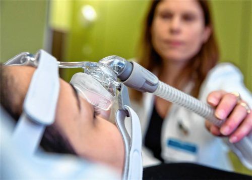 Eine Oberärztin und Leiterin des Schlaflabors demonstriert an einer Mitarbeiterin die Anbringung einer CPAP-Maske zur Behandlung von Schlaf-Apnoe. Foto dpa