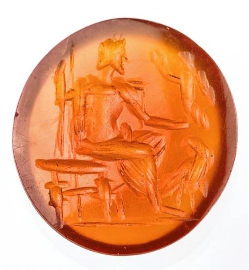 Karneolgemme vom Kastenfeld nördlich von Rosenheim: Links ist der thronende Jupiter mit einem Adler zu seinen Füßen dargestellt; in seiner rechten Hand hält er eine geflügelte Victoria mit Lorbeerkranz. Die Gemme ist ein Glanzstück der Römersammlung des Städtischen Museums. Foto  Städtisches Museum Rosenheim/Raphael Lichius