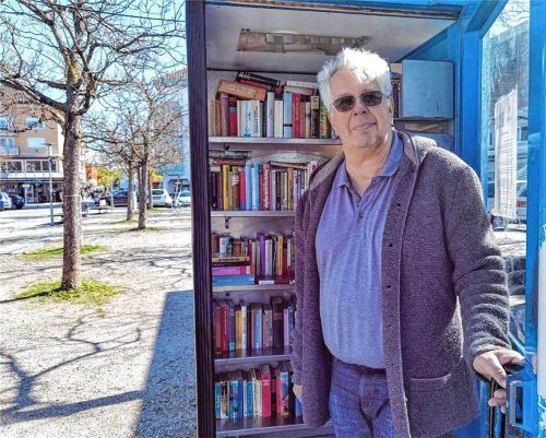 Klaus Penzenstadler kümmert sich als einer von zwei Bücherpaten um die umgenutzte Telefonzelle am Stadtplatz in Waldkraiburg. Foto Weinfurtner