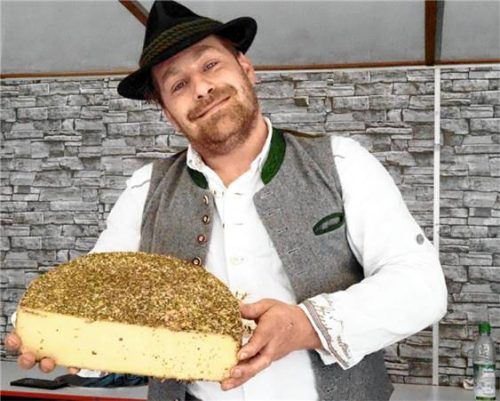 Matthias Bergbauer aus Simbach präsentiert ein großes Stück Kräuterkäse.
