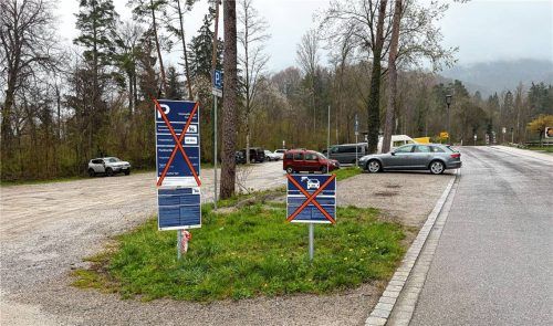 Parkplatz „Unteres Jenbachtal“ mit durchgestrichenen Hinweisschildern, die auf den außer Betrieb befindlichen Parkautomaten und die anstehenden neuen Parkgebühren hinweisen Foto Kriechbaumer
