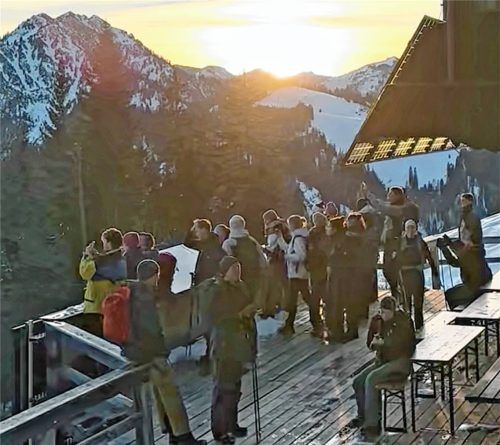 Studierende der Technische Universität München versammeln sich während der Projektwoche auf der Terrasse des Brünnsteinhauses in Oberaudorf und genießen den Blick auf die winterliche Berglandschaft .Foto re
