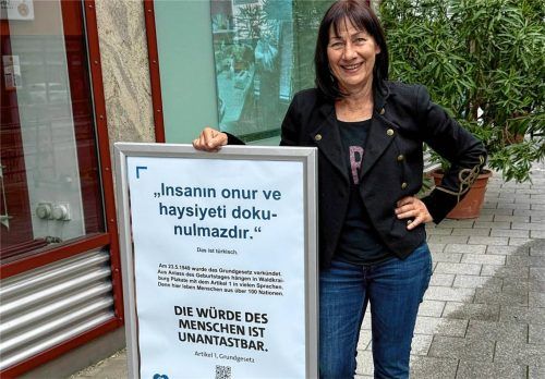 Bettina Rolle vom Netzwerk „Wir in Waldkraiburg – für Demokratie und Vielfalt“ mit einem Grundgesetz-Plakat vor der Antonius-Apotheke, die sich wie viele andere Einzelhändler und Gastronomiebetriebe an der Aktion beteiligen. Foto re