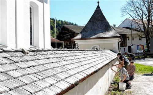 Die Firmlinge weißeln im Friedhof der Kirche „St. Michael“ in Sachrang die Friedhofsmauer. Foto Hötzelsperer