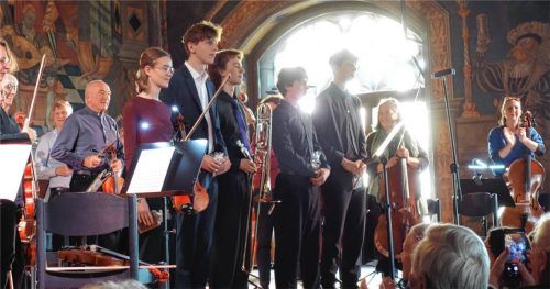 Die jungen Solisten (vorne, von links) Paula Martinez (Violine), Linus Bäumler (Klavier), Jakob Keil (Posaune), Simon Hofbauer (Kontrabass) und Leonard Kunst (Violine) sowie das Orchester nehmen den Applaus des Publikums entgegen. Foto Füchtner