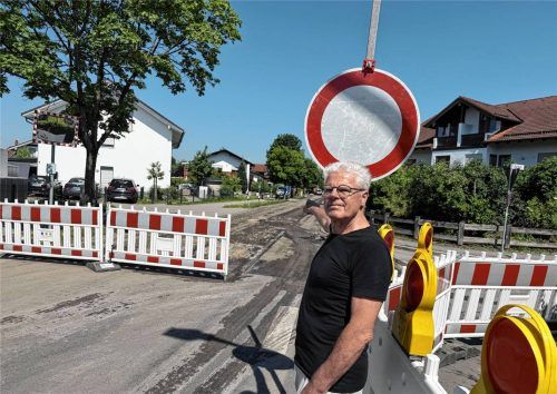 Dionys Schwinghammer, der Vorsitzende der Dorfgemeinschaft Mietraching, zeigt auf die für die Sanierung gesperrte Ebersberger Straße. Foto  Kotter