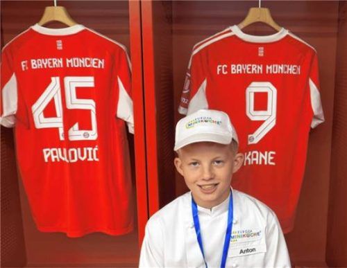 Ein Minikoch sitzt in der Kabine des FC Bayern München vor den Trikots der Spieler in der Allianz Arena. Foto Baumann