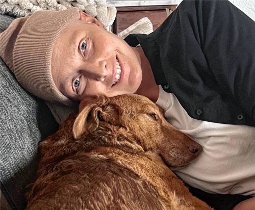 Endlich wieder daheim: Anne Willkommen schmust mit Hund Luki auf der Couch in Kolbermoor. Foto re