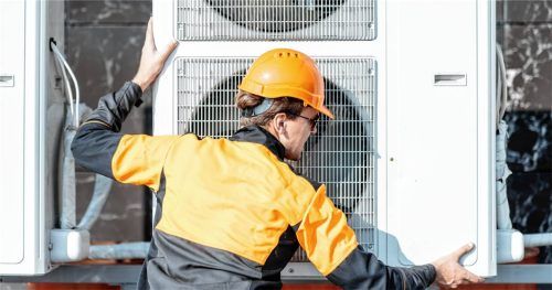 Fachgerechter Einbau: Ein Monteur installiert die Außeneinheit einer Wärmepumpe. Foto AdobeStock