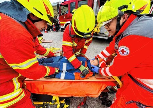 Feuerwehr- und Rettungskräfte versorgten bei einer Übung ein verletztes Kind auf einer Trage beim Blaulichttag in Mühldorf.