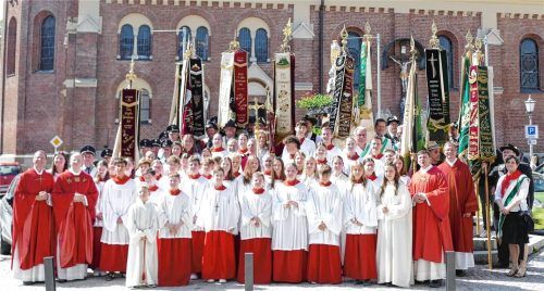 Gruppenfoto am Marktbrunnen mit den Geistlichen, Ministranten und Fahnenabordnungen: Kraiburg feierte das Jubiläum der Pfarrei.