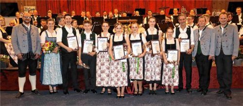Martin Grick vom Musikbezirk Inn-Chiemgau (links) sowie die Vorsitzenden vom Musikverein (von rechts) Sepp Stadler und Vitus Reger sind stolz auf ihre geehrten Musiker (von rechts, mit Urkunden) Georg Reger, Katharina Horny, Magdalena Huber, Magdalena Gasteiger, Katharina Horny, Barbara Obermaier, Marinus Bocksberger und Stefan Kirchberger sowie Ramona Kirchberger.Foto Strim