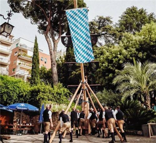 Nach kleiner Odyssee am Ziel: Der Maibaum wird im Garten der Casa Santa Maria in Rom aufgestellt – begleitet von Abordnungen aus Schwaig und Nußdorf.