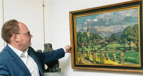 Priens Bürgermeister Andreas Friedrich justiert das Bild von Maler Paul Roloff in seinem Büro. Foto Berger