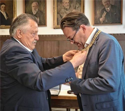 Sepp Baumann hängte Wasserburgs neuem Bürgermeister Bastian Wernthaler die Amtskette um.
