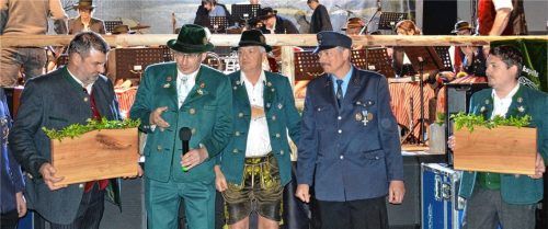 Sepp Gehmacher (links) hält das Holzbrett für die Feuerwehrjugend in der Hand und Trachtenvorsitzender Martin Heigermoser erklärt, dass dies symbolisch für eine Förderung der Jugendarbeit der Feuerwehr steht. Vereinsvorsitzender Sepp Mörtl (Musikkapelle) und Thomas Just (Feuerwehr) freuen sich. Das zweite Brett für die Jugendarbeit in der Musikkapelle überreicht Sepp Parzinger. 19 Dorfvereine haben zusammengelegt und 2.000 Euro für die Jugend gestiftet. Foto Eder