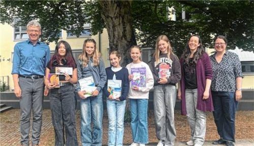 Siegerehrung: (von links) Schuldirektor Rainer Hoff mit Siegerin Lucia Ponciano, Amna Advic, Rosalie Lex, Clara Oberloher, Bettina Irob, Michelle Ganter von der Buchhandlung und Katharina Binz von der Fachschaft Englisch. Foto LTG Prien