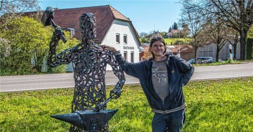 Uwe Huber neben dem Schmied. Dahinter steht das Rathaus von Tuntenhausen.Foto  Stache