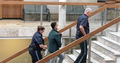 Abdelrehim M., angeklagt des Mordes an seiner Frau Eman E., wird von Justizbeamten in Traunstein in den Gerichtssaal begleitet. Foto Huber