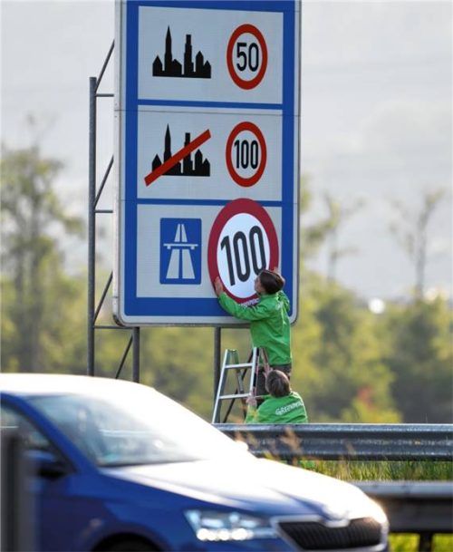 Aktivisten von Greenpeace haben an der A93 an einem Hinweisschild mit den Tempolimits auf deutschen Straßen die Angabe für Richtgeschwindigkeit 130 auf Autobahnen mit einem „Tempolimit 100“ überklebt. Foto dpa