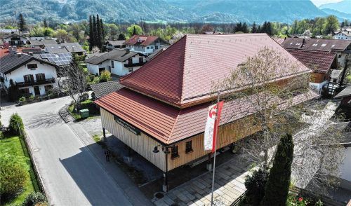Aus der Luft zeigt sich der sanierte Komödienstadel in neuer Geschlossenheit: Das fertige Dach des Flintsbacher Volkstheaters schützt ein Stück Dorfgeschichte – und schafft Raum für die Spielsaison 2026. Foto re