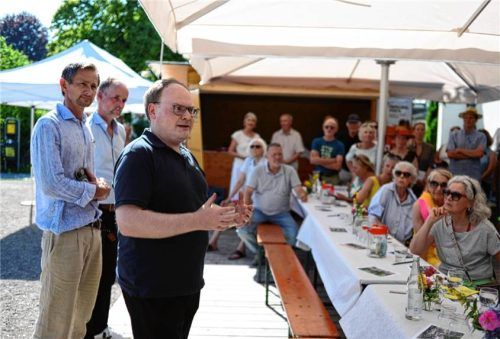 Bürgermeister Andreas Friedrich (vorne) bei seiner Rede vor den Interessierten bei der Veranstaltung „Lange Tafel der Baukultur“ am Priener Wendelsteinplatz. Mit dabei ist Architekt und Mitorganisator Josef Riefer (links). Foto KomMit