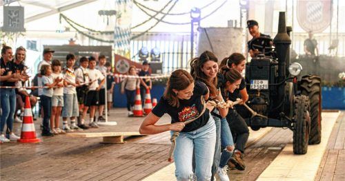 Die „Fire Girls“ strengten sich an: 3,3 Tonnen wog der alte Bulldog, den die Viererteams einmal durch das Festzelt zogen. Foto Johannes Thomae