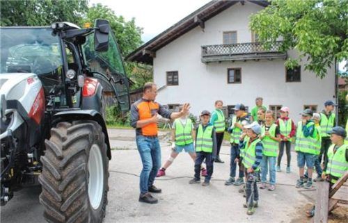 Ein Sicherheitsausbilder erklärt den Kindern am Traktor den „toten Winkel“. Fotos re