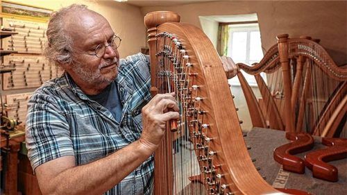 Harfenbauer Robert Poeverlein vom Harfenbau Fischer bei den letzten Handgriffen zur Überprüfung der fertigen Harfe. Foto Effner