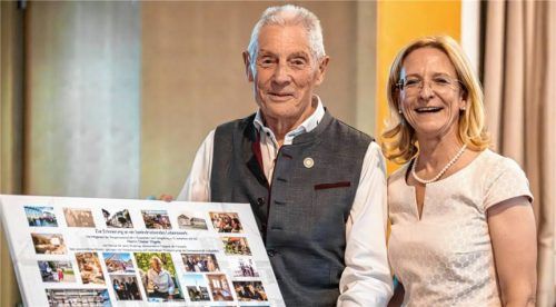 Als Zeichen der Anerkennung überreichte Elisabeth Siebeneicher an Dieter Vögele für sein 50-jähriges ehrenamtliches Wirken im Vorstand der Baugenossenschaft eine Ehrennadel sowie eine Fotocollage mit Stationen seines Wirkens.Foto Christian Tharovsky, STUDIO f8