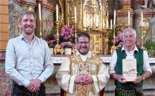 Anlässlich seines Priesterjubiläums überreichten der Vorsitzende des Pfarrgemeinderates Inzell-Weißbach, Andreas Geisreiter (links), und Weißbachs Kirchenpfleger Mathias Steinbacher Pfarrer Thomas Weinzierl eine Spendenbox. Foto Wegscheider