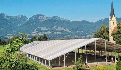 Auf der Nußdorfer Festwiese entsteht das riesige Zelt für das 106. Gaufest des Bayerischen Inngau-Trachtenverbands. Rund 80 Helfer arbeiten bei sommerlicher Hitze Hand in Hand. Im Hintergrund bilden St. Leonhard und der Wendelstein die Kulisse für das Fest.Foto Steffenhagen