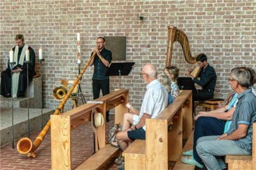 Berührende Musik: Sebastian Krause spielt das Alphorn und Johann Niedermaier die Harfe während des ökumenischen Gottesdienstes in der Kirche St. Johann im Gebirg auf der Winklmoosalm. Foto Flug