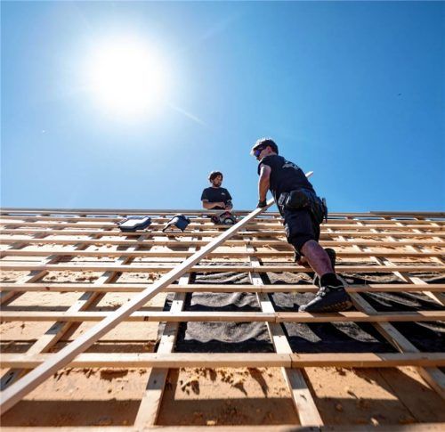 Dachdecker arbeiten unter der sengenden Sonne bei über 30 Grad auf dem Dach eines Hauses. Foto dpa